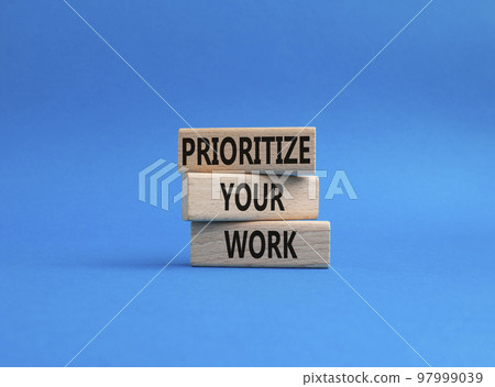 Priority symbol. Wooden blocks with words 'Prioritize your work'. Beautiful blue background. Business and 'Prioritize your work' concept. Copy space. 97999039