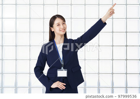 Business woman pointing diagonally upward Business woman pointing diagonally upward 97999536