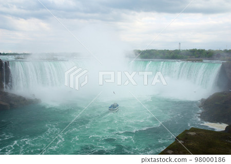 NIAGARA FALLS, ONTARIO, CANADA - MAY 20th 2018: Touristic boat on Horseshoe Falls, also known as Canadian Falls NIAGARA FALLS, ONTARIO, CANADA - MAY 20th 2018: Touristic boat on Horseshoe Falls, also known as Canadian Falls 98000186