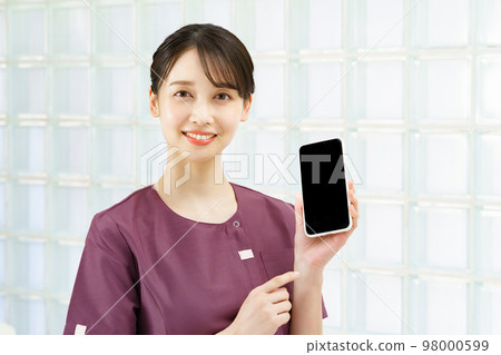 A woman in a uniform showing the screen of a smartphone 98000599