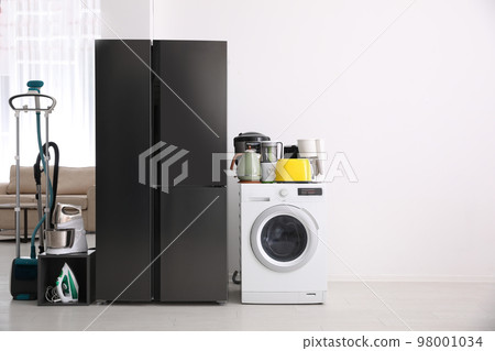 Refrigerator and different household appliances in room. Space for text Refrigerator and different household appliances in room. Space for text 98001034