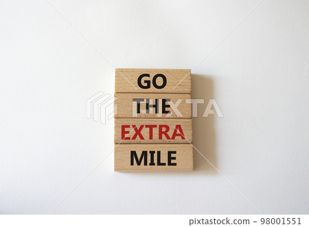 Go the extra mile symbol. Wooden blocks with words Go the extra mile. Beautiful white background. Business and Go the extra mile concept. Copy space. 98001551