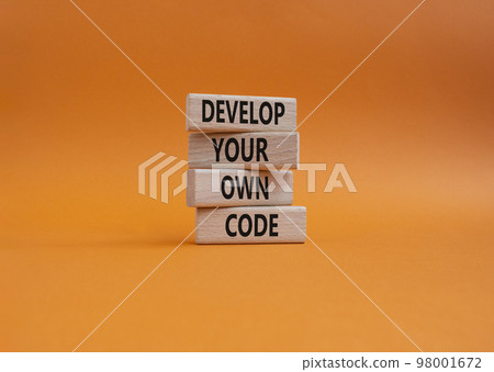 Develop your own code symbol. Concept words Develop your own code on wooden blocks. Beautiful orange background. Business and Develop your own code concept. Copy space. 98001672