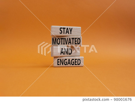 Stay Motivated and Engaged symbol. Concept words Stay Motivated and Engaged on wooden blocks. Beautiful orange background. Business and Stay Motivated and Engaged concept. Copy space 98001676