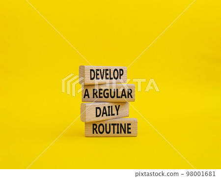 Develop a regular daily routine symbol. Concept words Develop a regular daily routine on wooden blocks. Beautiful yellow background. Business and Develop a regular daily routineconcept. Copy space. 98001681