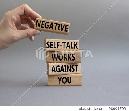 Negative self-talk works against you symbol. Concept words Negative self-talk works against you on wooden blocks. Beautiful grey background. Businessman hand. Psychological concept. Copy space Negative self-talk works against you symbol. Concept words Negative self-talk works against you on wooden blocks. Beautiful grey background. Businessman hand. Psychological concept. Copy space 98001703