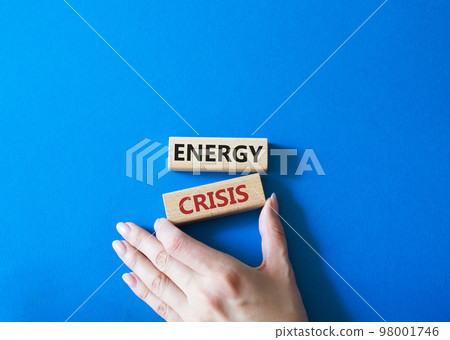 Energy crisis symbol. Concept word Energy crisis on wooden blocks. Businessman hand. Beautiful blue background. Business and Energy crisis concept. Copy space Energy crisis symbol. Concept word Energy crisis on wooden blocks. Businessman hand. Beautiful blue background. Business and Energy crisis concept. Copy space 98001746