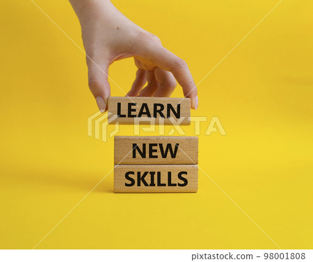Learn new skills symbol. Concept words 'Learn new skills' on wooden blocks. Beautiful yellow background. Businessman hand. Business and Learn new skills concept. Copy space. Learn new skills symbol. Concept words 'Learn new skills' on wooden blocks. Beautiful yellow background. Businessman hand. Business and Learn new skills concept. Copy space. 98001808