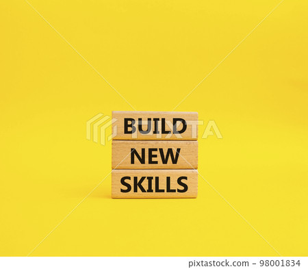 Build New skills symbol. Concept word Build New skills on wooden blocks. Beautiful yellow background. Business and Build New skills concept. Copy space 98001834
