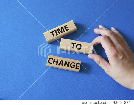Time to change symbol. Concept word Time to change on wooden blocks. Businessman hand. Beautiful blue background. Business and Time to change concept. Copy space 98001875