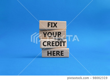 Fix your credit here symbol. Concept words Fix your credit here on wooden blocks. Beautiful blue background. Business and Fix your credit here concept. Copy space. 98002319