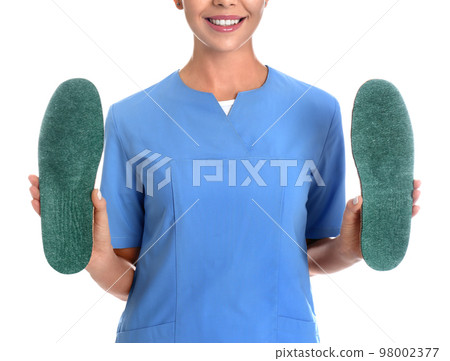 Female orthopedist showing insoles on white background, closeup 98002377