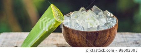 Aloe vera and aloe cubes in a wooden bowl. Aloe Vera gel almost use in food, medicine and beauty industry BANNER, long format 98002393