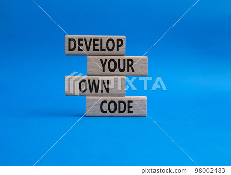 Develop your own code symbol. Concept words Develop your own code on wooden blocks. Beautiful blue background. Business and Develop your own code concept. Copy space. 98002483