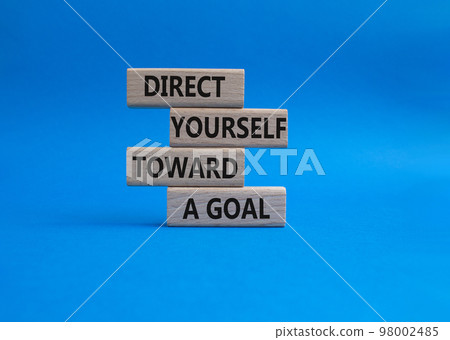 Direct yourself toward a goal symbol. Wooden blocks with words Direct yourself toward a goal. Beautiful blue background. Business and Direct yourself toward a goal concept. Copy space. Direct yourself toward a goal symbol. Wooden blocks with words Direct yourself toward a goal. Beautiful blue background. Business and Direct yourself toward a goal concept. Copy space. 98002485