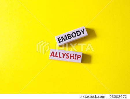 Embody Allyship symbol. Concept word Embody Allyship on wooden blocks. Beautiful yellow background. Business and Embody Allyship concept. Copy space 98002672