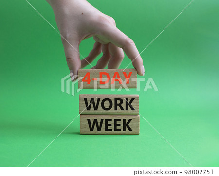 4-day work week symbol. Concept words 4-day work week on wooden blocks. Beautiful green background. Businessman hand. Business and 4-day work week concept. Copy space 98002751