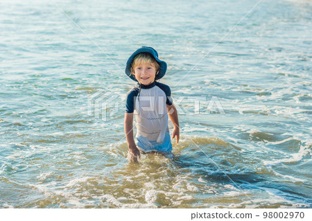 happy little boy running on sand tropical beach 98002970