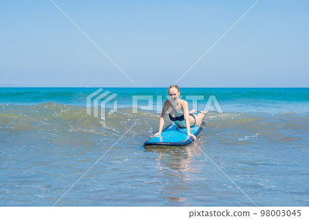 A woman learns to surf on the foam. Bali Indonesia 98003045