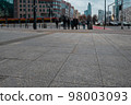 The sidewalk is paved with granite tiles against the background of a pedestrian crossing. 98003093