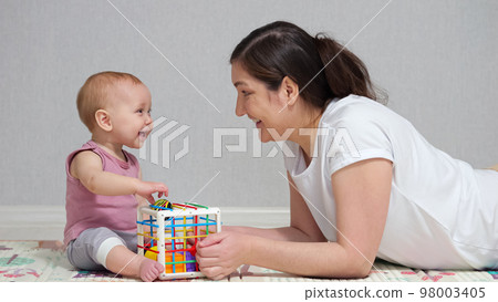Mother plays toys with excited baby girl and enjoys weekend 98003405