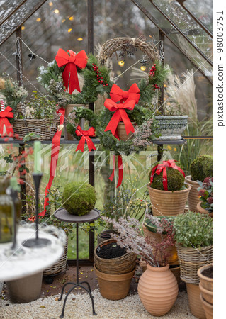 Glasshouse decorated with wreaths and red bows for a winter holidays Glasshouse decorated with wreaths and red bows for a winter holidays 98003751