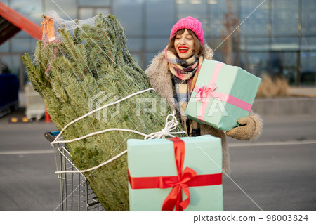 Woman buys Christmas tree and presents at mall Woman buys Christmas tree and presents at mall 98003824