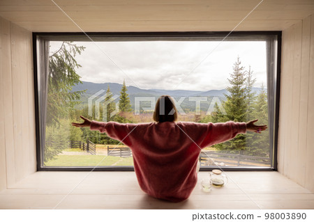 Woman rests in house at mountains 98003890