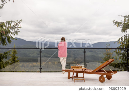 Woman rests on terrace in mountains Woman rests on terrace in mountains 98003929