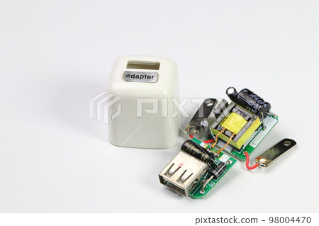 inside of usb charger adapter on white background, broken Charger gadgets isolated on a white background. The concept of charging technology to mobile phones. inside of usb charger adapter on white background, broken Charger gadgets isolated on a white background. The concept of charging technology to mobile phones. 98004470