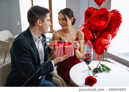 Valentine's Day concept. A loving couple celebrating Valentine's Day in the restaurant. Valentine's Day concept. A loving couple celebrating Valentine's Day in the restaurant. 98004849
