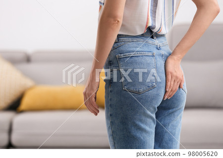 Young woman suffering from hemorrhoid at home, closeup 98005620