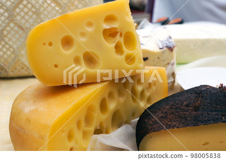 Traditional Hard Cheese Emmental with many Holes in it at the Food Market. 98005838