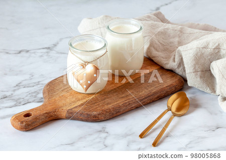 Two portions of joghurt, served on a cutting board, Valentine day breakfast idea 98005868