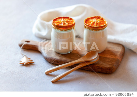 Two portions of joghurt decorated with dry orange slices, winter breakfast Two portions of joghurt decorated with dry orange slices, winter breakfast 98005884