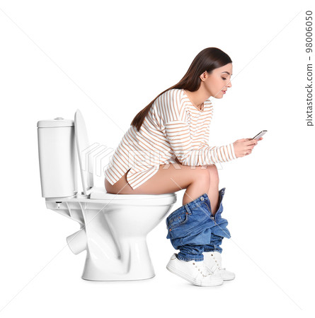 Woman with smartphone sitting on toilet bowl, white background 98006050