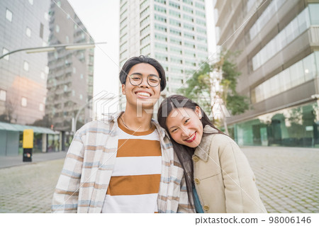 Portrait of a beautiful asian couple looking at camera during the sunset. 98006146