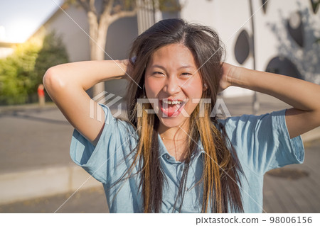 Portrait of a beautiful asian woman smiling and looking at camera outdoors 98006156
