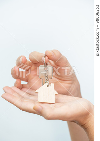 Close-up of beautiful hands of a woman with the new home keys on white background. Close-up of beautiful hands of a woman with the new home keys on white background. 98006253