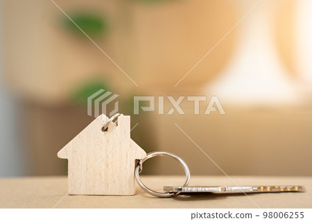 House keys on keyring in the shape of a wooden house with copy-space for text House keys on keyring in the shape of a wooden house with copy-space for text 98006255