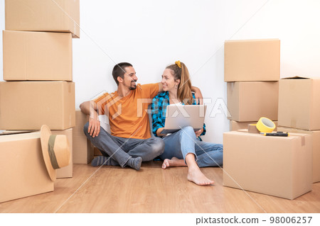 Household Move. Attractive couple with moving boxes becoming independent and opening a new home. 98006257