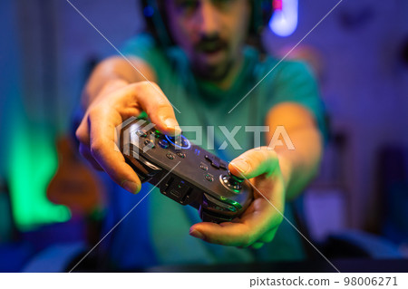 Modern gamer plays video games with gamepad on a technological room entertainment, cyberspace. 98006271