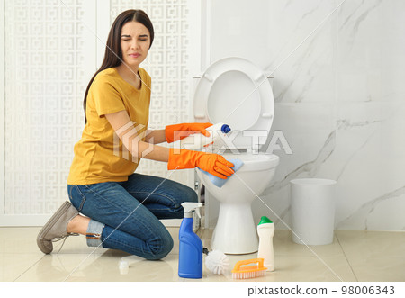 Young woman feeling disgust while cleaning Young woman feeling disgust while cleaning 98006343
