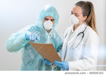 Doctors and nurses working in the hospitals and fighting the coronavirus. Doctors are heroes. Doctors in the protective suits and masks looking for a cure for the disease.  98006383