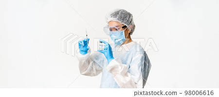 Asian woman doctor or nurse in personal protective equipment, medical mask and gloves, filling syringe with covid-19 vaccine, vaccinating patients, white background Asian woman doctor or nurse in personal protective equipment, medical mask and gloves, filling syringe with covid-19 vaccine, vaccinating patients, white background 98006616