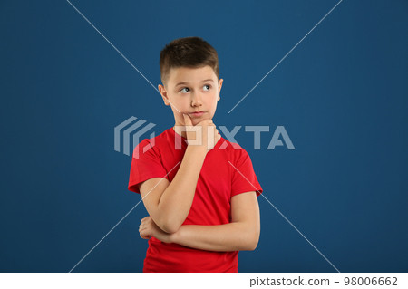 Portrait of emotional preteen boy on blue background 98006662