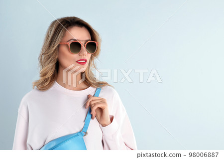Young woman wearing stylish sunglasses on light grey background. Space for text Young woman wearing stylish sunglasses on light grey background. Space for text 98006887