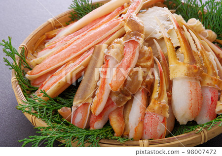 A lot of crab legs served in a bamboo colander 98007472