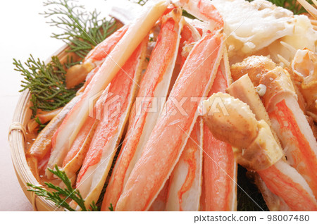 A lot of crab legs served in a bamboo colander 98007480