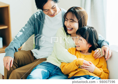 A young family relaxing in the living room A young family relaxing in the living room 98007596